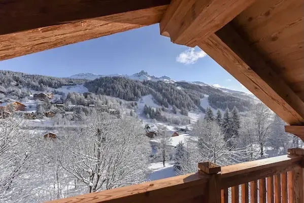 Montagne enneigée vue depuis le balcon d’un chalet