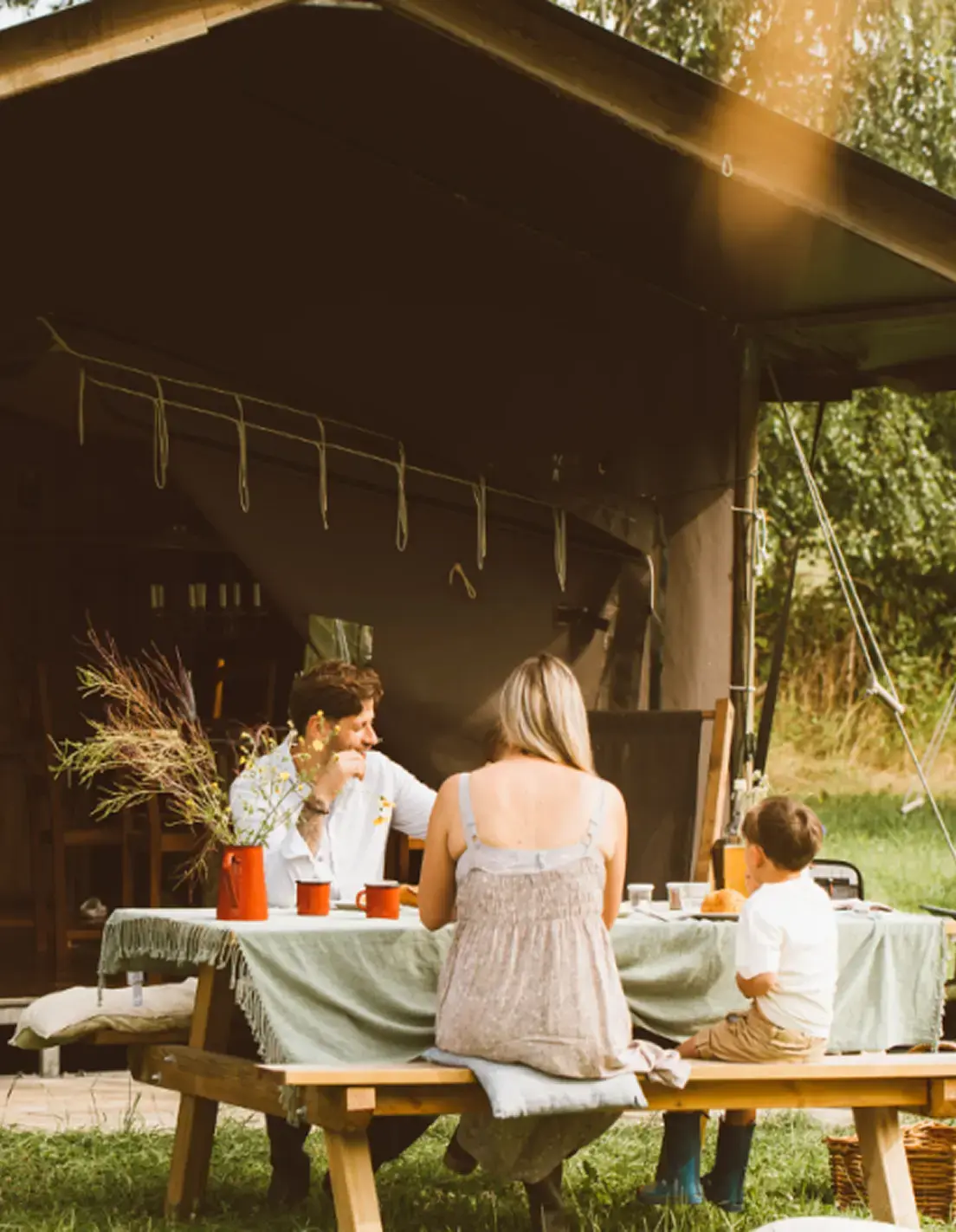 GreenGo - Famille déjeunant sur une table de picnique en pleine nature.