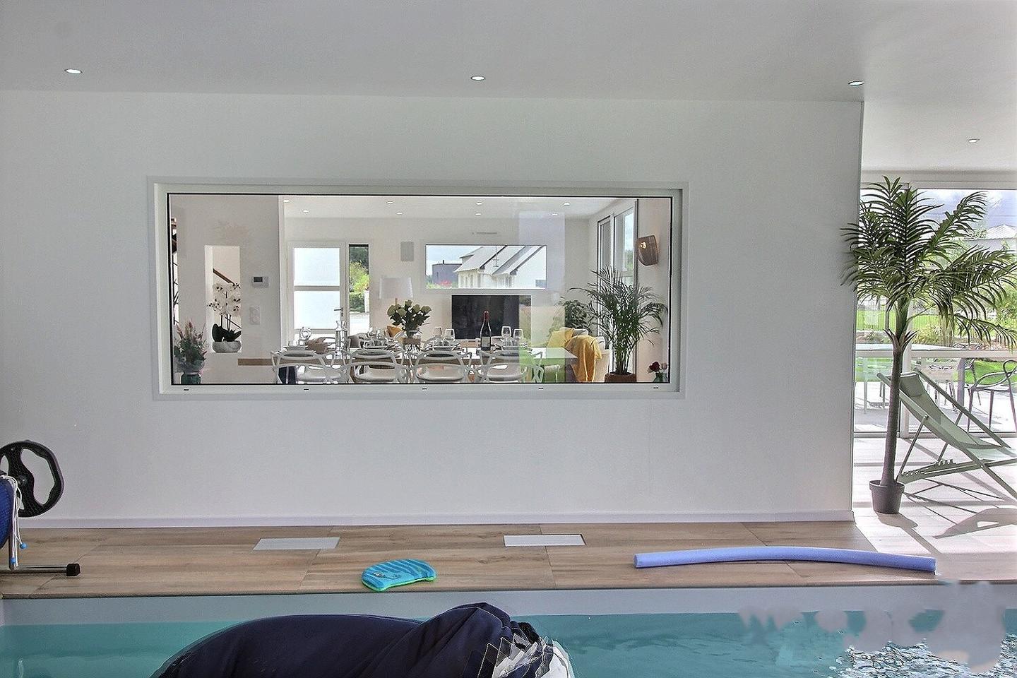 Piscine intérieure chauffée toute l'année visible depuis la pièce de vie
