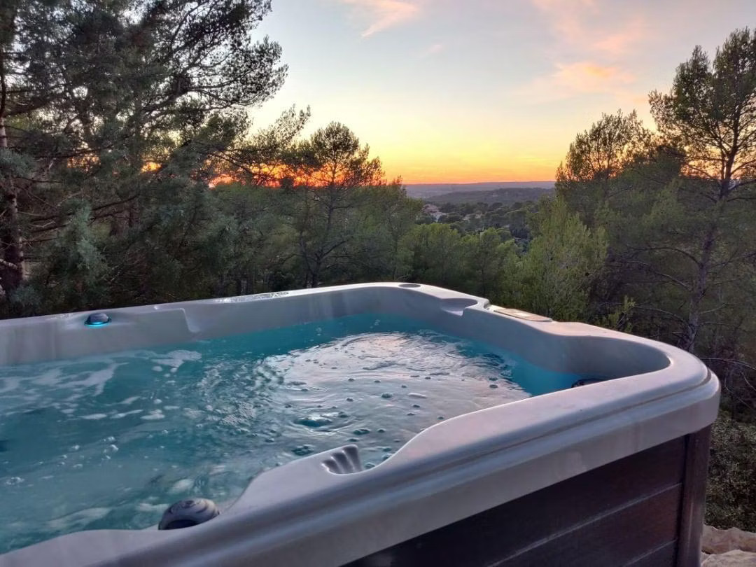 Jacuzzi extérieur surplombant la campagne aixoise avec une vue magnifique jusqu'aux Alpilles et Mont Ventoux